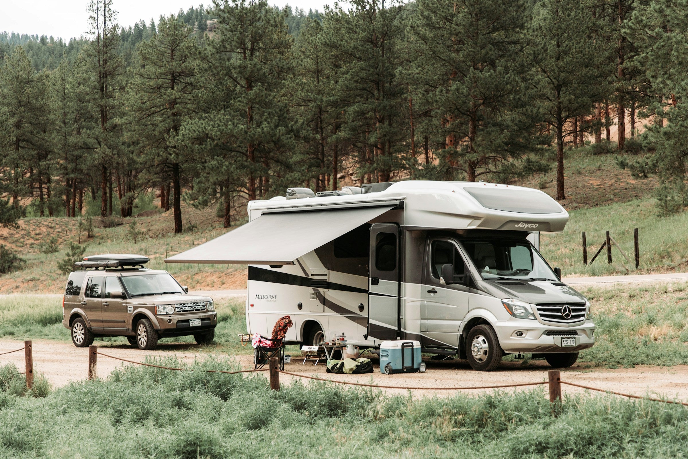 a camper parked next to a truck on a dirt road